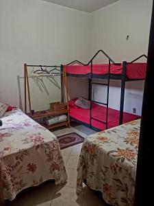 2 literas en una habitación con sábanas rojas en Verdes Hostel Palmas-TO, en Palmas