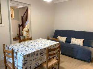 ein Wohnzimmer mit einem blauen Sofa und einem Tisch in der Unterkunft Maison à Perros-Guirec avec WIFI, proche centre-ville et plage, cour fermée, parking privé - FR-1-368-324 in Perros-Guirec