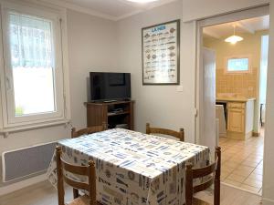 ein Esszimmer mit Tisch und Fernseher in der Unterkunft Maison à Perros-Guirec avec WIFI, proche centre-ville et plage, cour fermée, parking privé - FR-1-368-324 in Perros-Guirec
