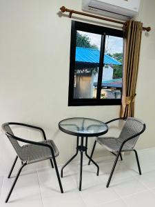 mesa, 2 sillas, mesa y ventana en บ้านโกจุยรีสอร์ต, 