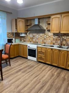 La cuisine est équipée de placards en bois et d'un four avec plaques de cuisson. dans l'établissement Apartment Bograch, à Moukatcheve