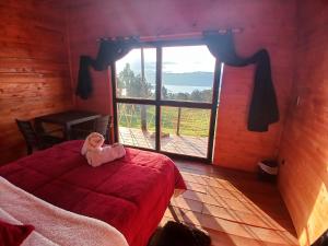 uma criança sentada numa cama num quarto com uma janela em Hospedaje cabaña Guatavita Finca las Acacias em Guatavita