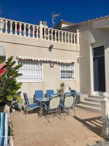 Un patio con una mesa y sillas frente a una casa. en Villa Del Mar, en Alicante