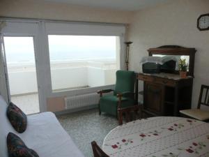 salon z łóżkiem, biurkiem i oknem w obiekcie Appartement Front de Mer avec Terrasse - 2 Chambres, Animaux Acceptés - FR-1-674-16 w mieście Berck-sur-Mer