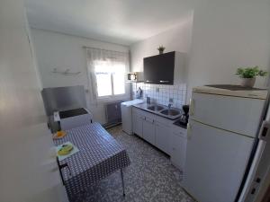 eine kleine Küche mit Kühlschrank und Spüle in der Unterkunft Appartement Berck-Plage, 3 pièces, 6 personnes - FR-1-674-16 in Berck-sur-Mer