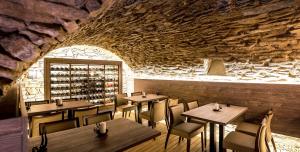 a restaurant with tables and chairs and a stone wall at Boutique Hotel Hviezdoslav in Kežmarok