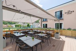 ザ・マンブルズにあるOyster Houseのデッキにテーブルと椅子を用意したレストラン