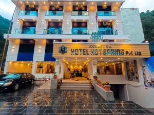 un hôtel avec une voiture garée devant lui dans l'établissement Shrestha Hotel Hotspring PVT.LTD, à Beni