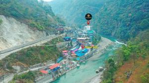 Shrestha Hotel Hotspring PVT.LTD في Beni: اطلاله على نهر وفيه بيوت على جبل