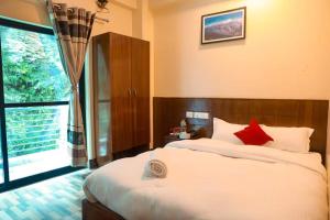 a bedroom with a large bed and a large window at Shrestha Hotel Hotspring PVT.LTD in Beni