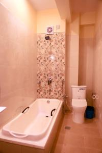 a bathroom with a tub and a toilet at Shrestha Hotel Hotspring PVT.LTD in Beni