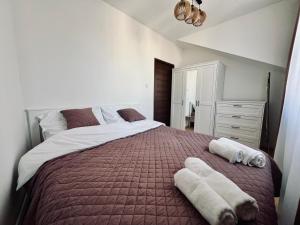 Apartament Wisteria في برزيميسل: غرفة نوم بسرير كبير عليها مناشف