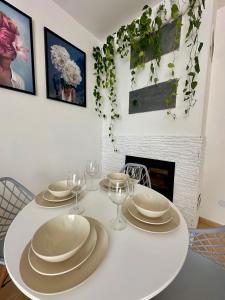 Apartament Wisteria في برزيميسل: طاولة بيضاء عليها صحون واكواب للنبيذ