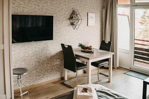 Zimmer mit einem Schreibtisch und einem TV an der Wand in der Unterkunft Haus Vier Jahreszeiten am See HS 473 in Goslar