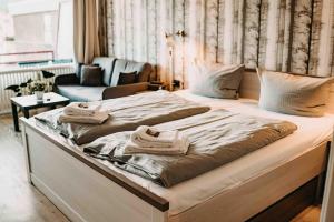 ein großes Bett mit Handtüchern darauf in einem Schlafzimmer in der Unterkunft Haus Vier Jahreszeiten am See HS 473 in Goslar
