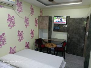 Habitación con cama, mesa y TV. en OYO Mahavir Guest House, en Cuttack