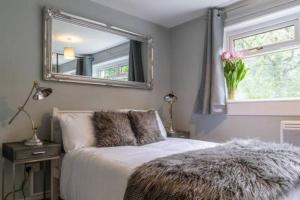 a bedroom with a bed with a mirror on the wall at Cosy 1 Bed with Parking in City Centre in Glasgow