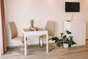 ハーネンクレー・ボックスヴィーゼにあるHaus Vier Jahreszeiten am See HS 939のテレビ付きの客室で、テーブルと椅子が備わります。