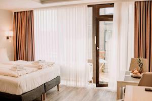 - une chambre avec un lit et une grande fenêtre dans l'établissement Haus Vier Jahreszeiten am See HS 939, à Hahnenklee