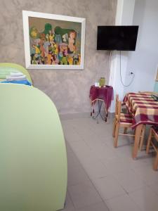 sala de estar con tabla de surf, mesa y TV en L&l en Acerenza