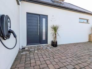 una puerta azul en una casa blanca con una maceta en Little Beach Cabin en Newquay