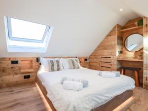 1 dormitorio con 1 cama blanca grande y ventana en Little Beach Cabin en Newquay