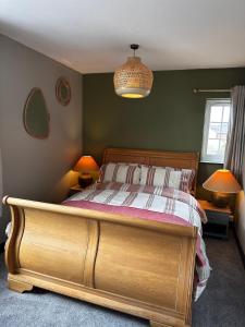 a bedroom with a wooden bed with two lamps at The Hideaway in Stratford-upon-Avon