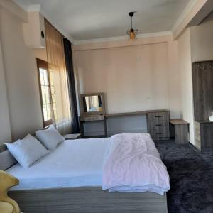 1 dormitorio con 1 cama grande con sábanas blancas en Yeşilgöl doğa evleri, en Tokat