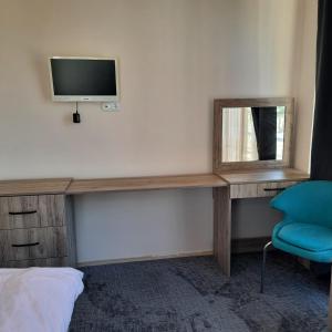 a room with a tv and a chair and a mirror at Yeşilgöl doğa evleri in Tokat