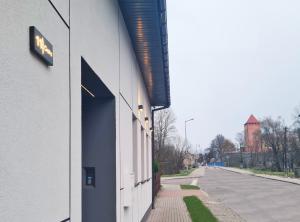 ein Gebäude mit einem Schild an der Straßenseite in der Unterkunft Apartment Quiet Street 11/5E in Oświęcim