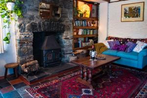 a living room with a couch and a fireplace at Tan Y Bryn in Llanrhystyd