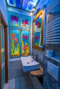 ein Badezimmer mit einem Waschbecken und Buntglasfenstern in der Unterkunft HB apartments Zurab Zhvania in Tbilisi City