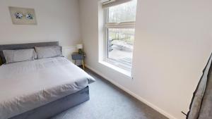 een slaapkamer met een bed en een raam bij A Prestwich Apartments M25 in Manchester