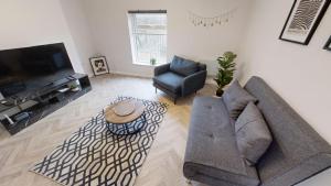 a living room with a couch and chairs and a television at A Prestwich Apartments M25 in Manchester