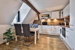a kitchen with white cabinets and a table and chairs at LK1 top Lage Innenstadtapartment in Nürnberg
