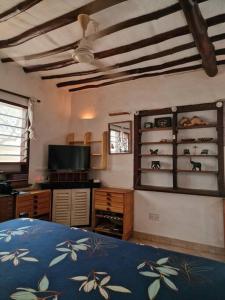une chambre avec un lit et une télévision et un plafond dans l'établissement Cozy Cat House, à Diani Beach