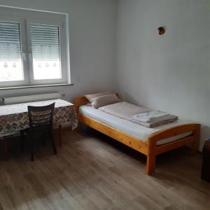 a bedroom with two beds and a table and a chair at Backstubencafe Beck in Ansbach
