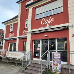 a red building with a cafe sign in front of it at Backstubencafe Beck in Ansbach
