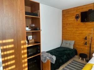 a small bedroom with a bed and a tv at Górska Ostoja in Muszyna