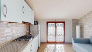 a kitchen with white cabinets and a stove top oven at CliVio - By Ligooria in Pietra Ligure