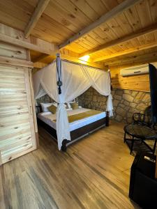 een slaapkamer met een bed met een klamboe bij Suuyla Butik Otel in Edremit