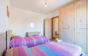 two beds in a room with pink and purple sheets at Badolato Apartments in Badolato