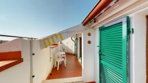 a room with a green garage door and a table at CliVio - By Ligooria in Pietra Ligure
