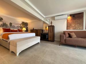 1 dormitorio con 1 cama y 1 sofá en Suuyla Butik Otel, en Edremit
