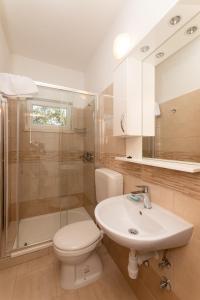 a bathroom with a toilet and a sink and a shower at Holiday Home Malačnica in Supetar +7 photos