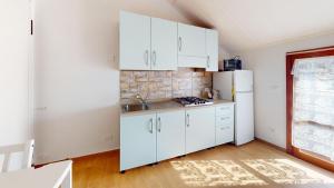 a kitchen with white cabinets and a white refrigerator at CliVio - By Ligooria in Pietra Ligure +13 photos
