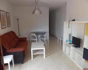 a living room with a couch and a table at Apartamentos Taravilla P26 in Puerto de Mazarrón