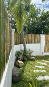 a palm tree in a yard next to a fence at The White Villa in Lipa in Lipa