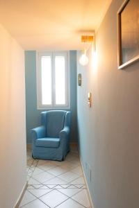 una sedia blu in un corridoio con finestra di Le Camere di Olivia a Ravenna