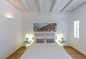 a white bedroom with a large bed in a room at Fortan 5* villa in Mýkonos City